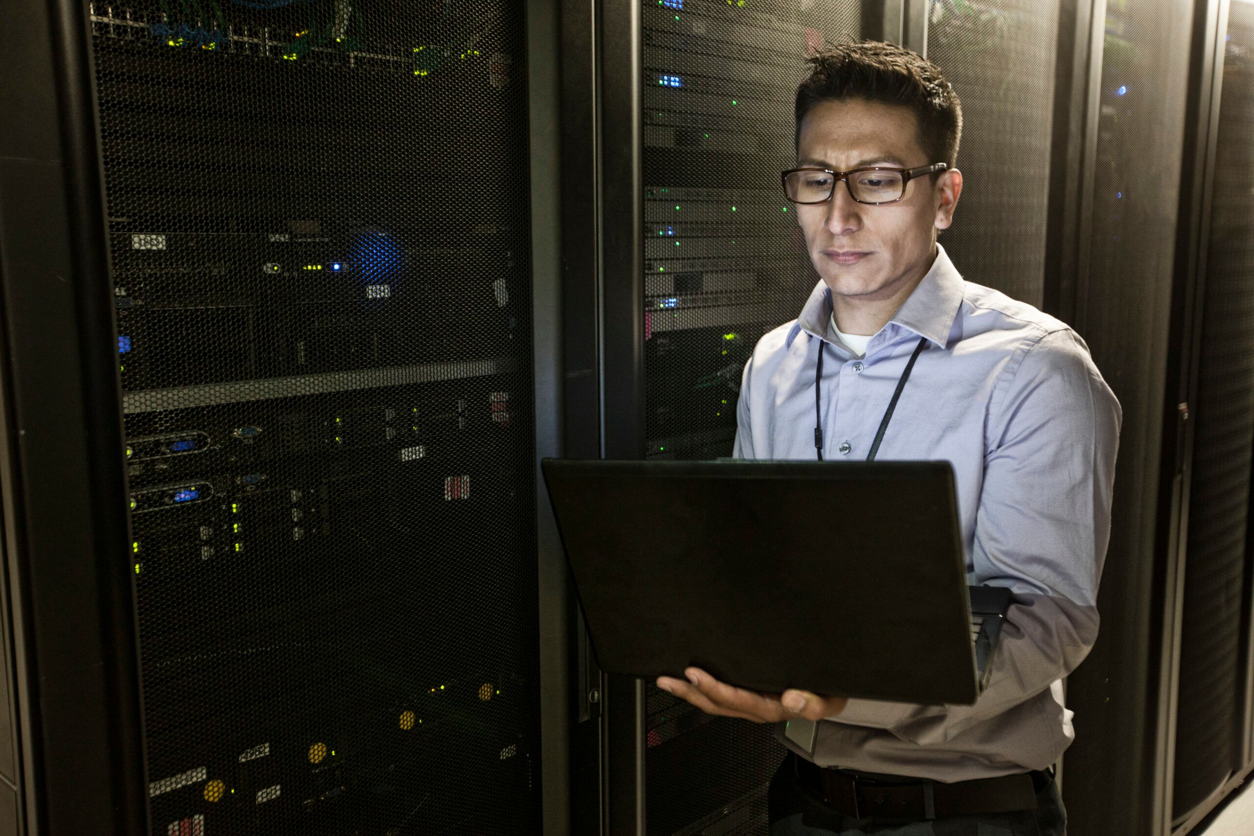 Professionista IT che esegue la gestione delle patch Linux in un data center con rack di server e apparecchiature di rete