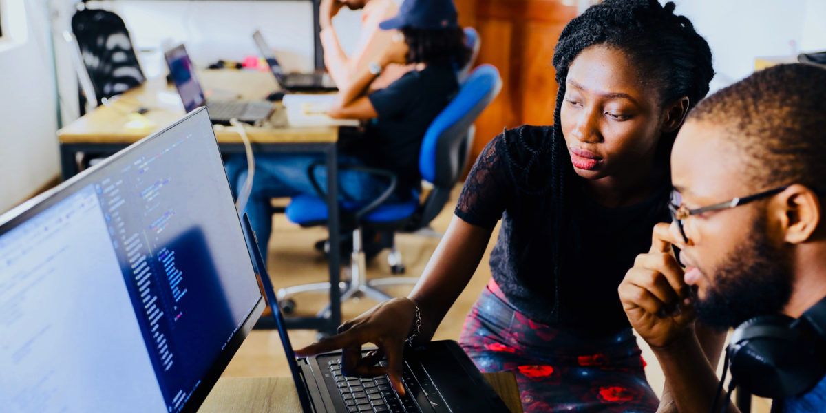Persone che lavorano alla scrivania con un computer portatile in un ambiente d’ufficio