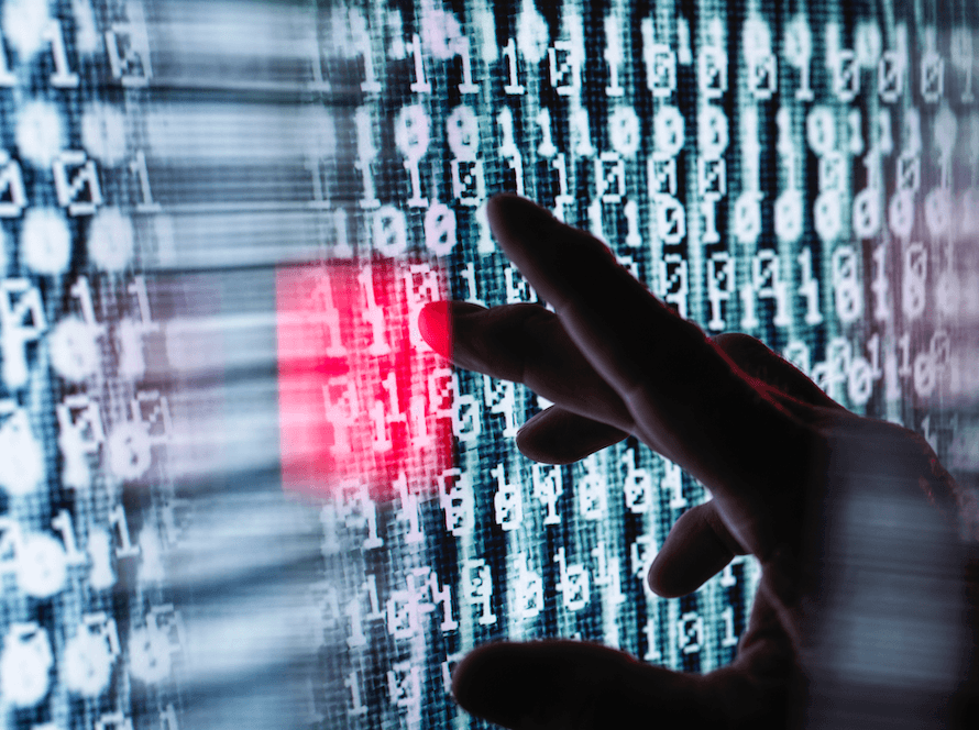 Fingers seen in silhouette touch a computer screen filled with ones and zeros.
