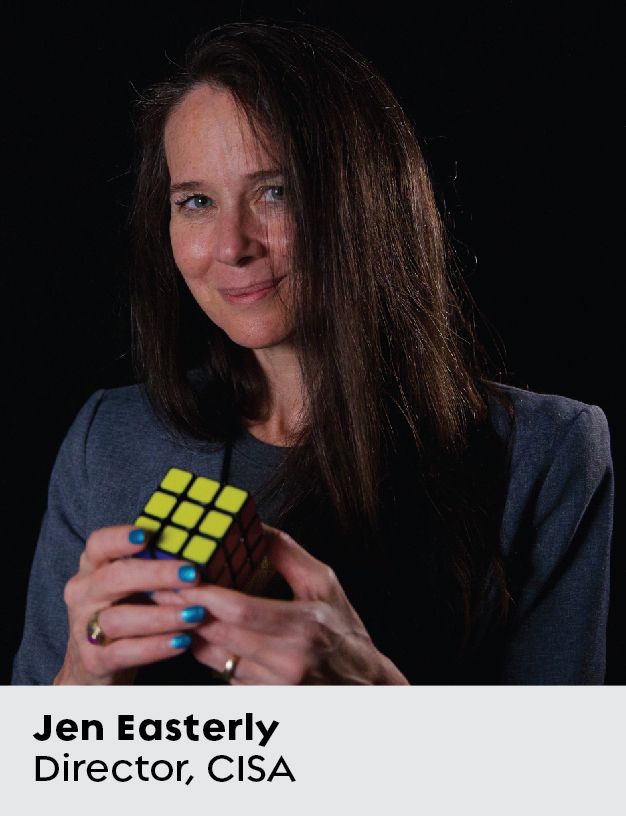Primo piano di una donna con un blazer blu che tiene in mano un cubo di Rubik