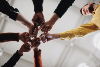 Un gruppo eterogeneo di mani unite in cerchio, viste dall’alto