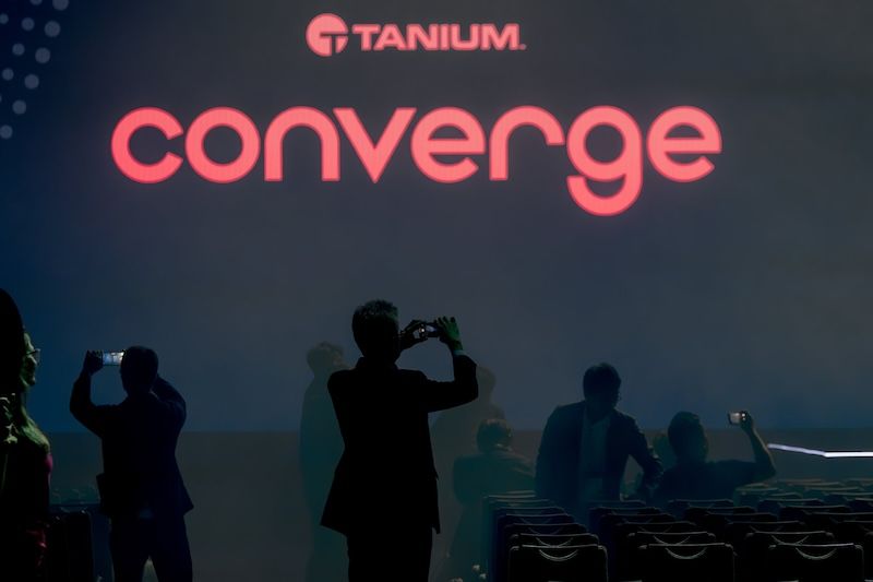 Palco CONVERGE 2024 con il logo “ Tanium ” e i partecipanti