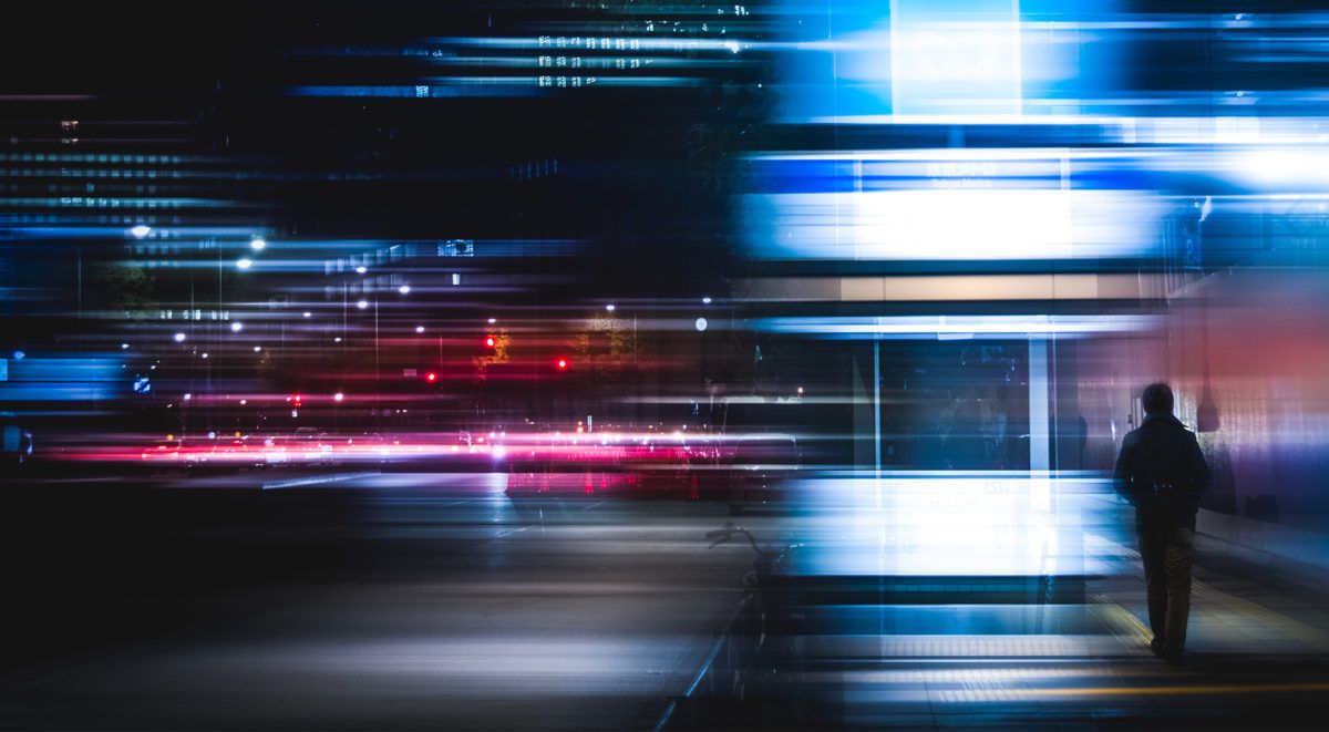 Illustrazione di una persona circondata da flussi di dati digitali blu e rossi