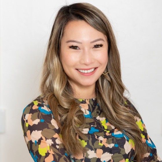 Headshot of woman with brown and blonde hair in colorful patterned top