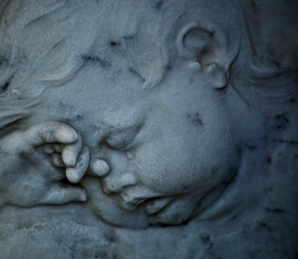 Scultura in pietra raffigurante un cherubino addormentato