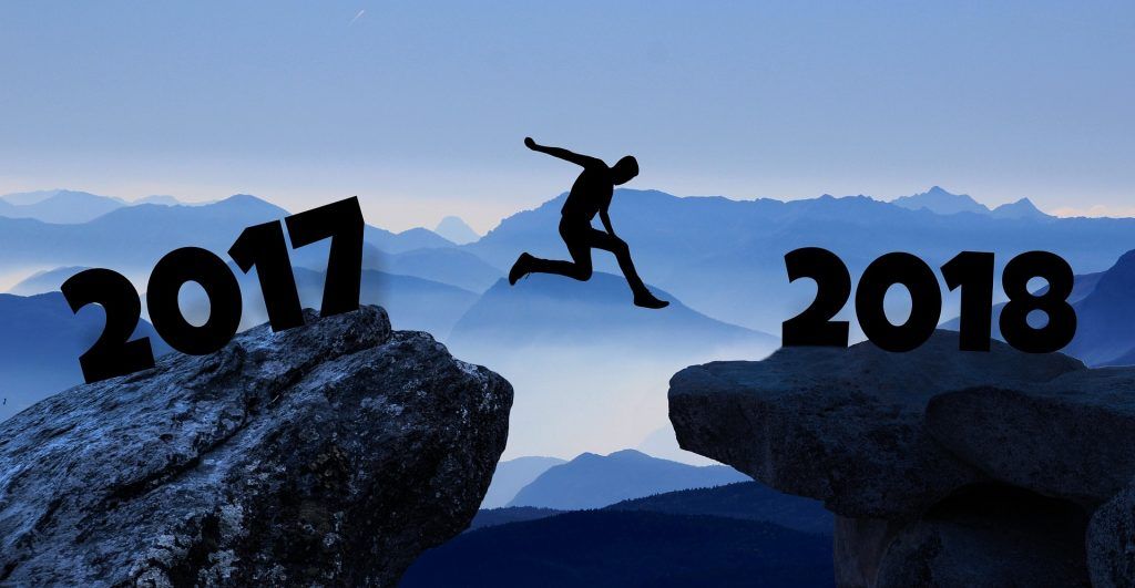 Sagoma di una persona che salta tra le rocce contrassegnate con i numeri 2017 e 2018
