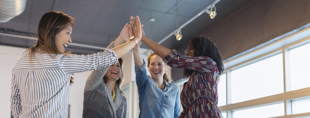 Un gruppo di donne in ufficio che si danno il cinque