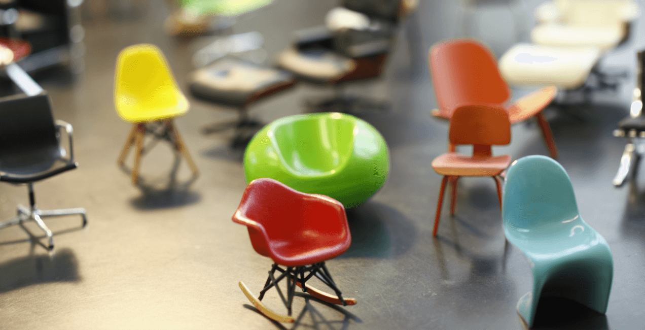 Una collezione di sedie di design in miniatura con forme sinuose e colori vivaci.