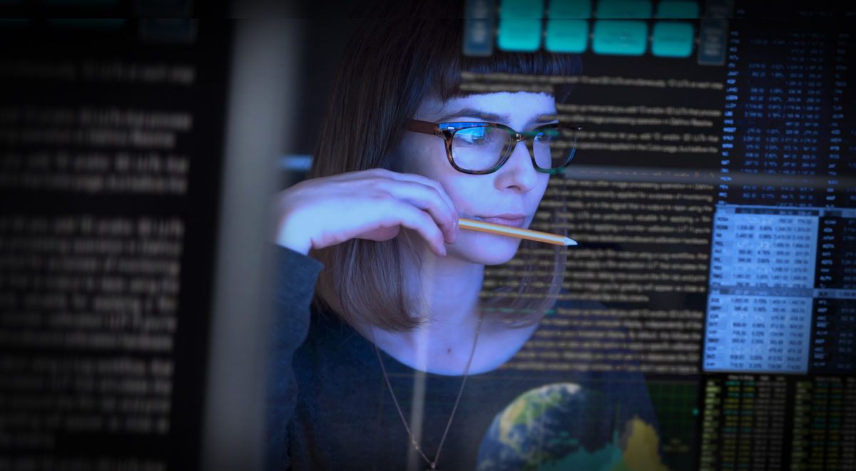 Female professional in blue blazer holding data cables with server room backdrop