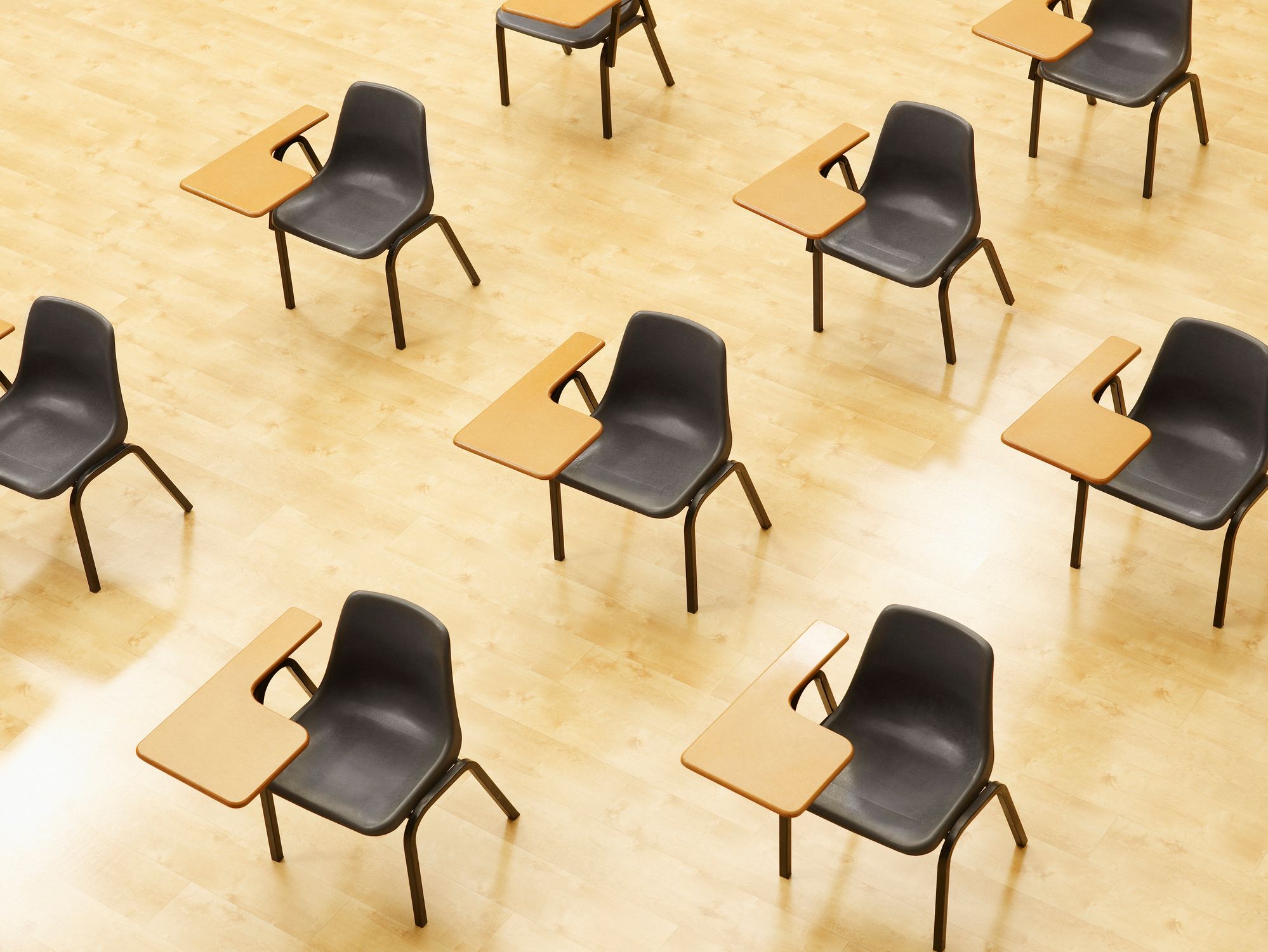 File di banchi disposte in diagonale in un'aula vuota.