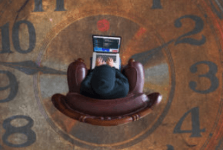Illustrazione di mani che reggono un computer portatile sopra un grande orologio, a simboleggiare la gestione del tempo