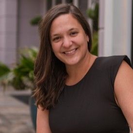 Headshot of woman with dark hair smiling outdoors