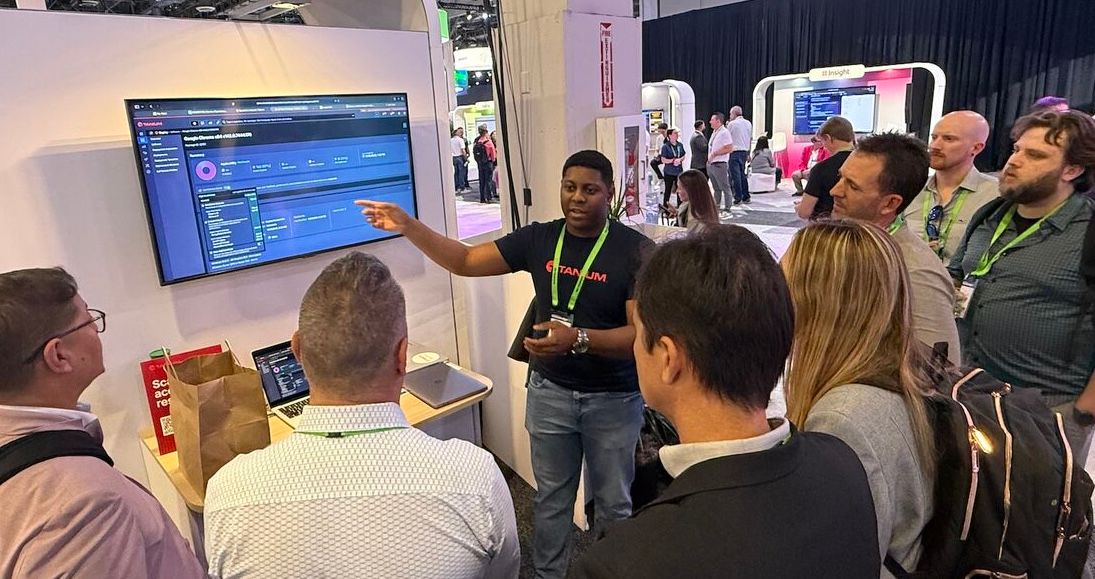Group of people watching a product demonstration at a conference booth
