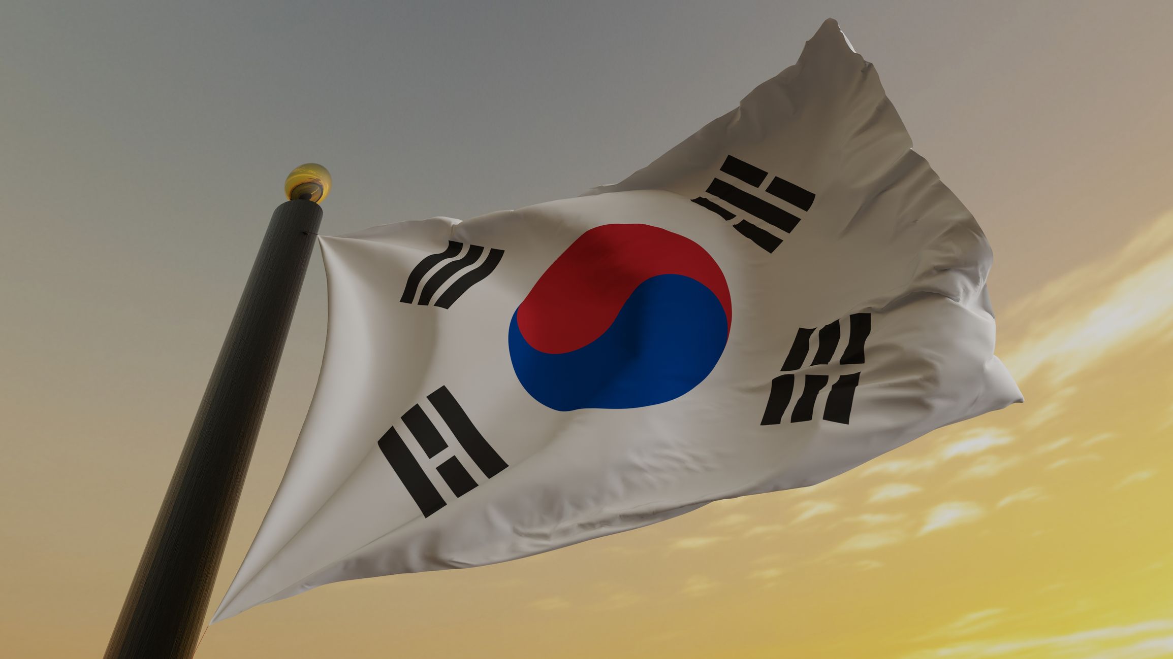 La bandiera della Corea del Sud ondeggia nel vento. È caratterizzata da un cerchio vorticoso rosso e blu su un campo bianco, circondato da quattro trigrammi, simboli con tre linee nere.