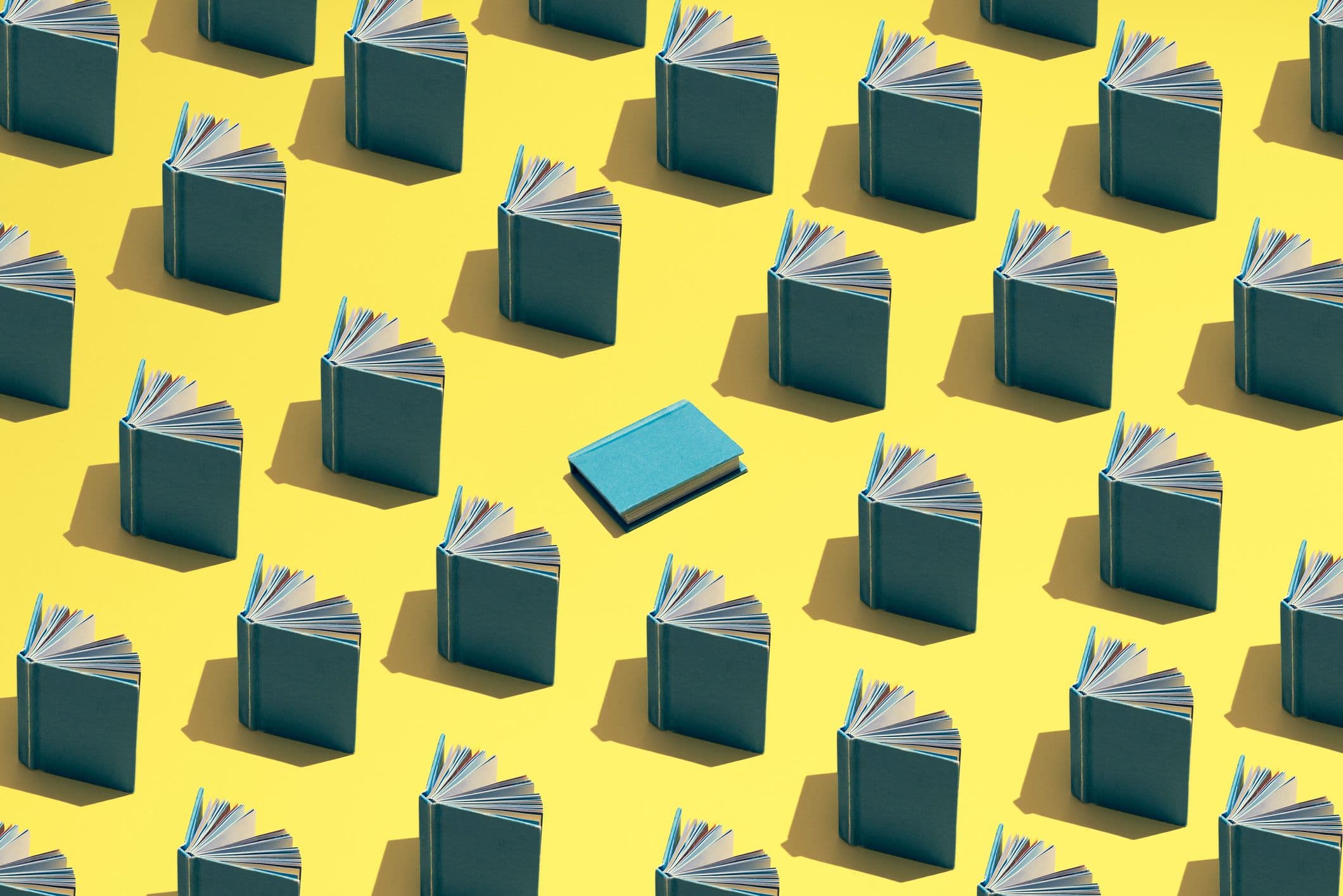 Immagine in evidenza del blog. Un'illustrazione di libri aperti disposti in file su uno sfondo giallo e un libro blu al centro.
