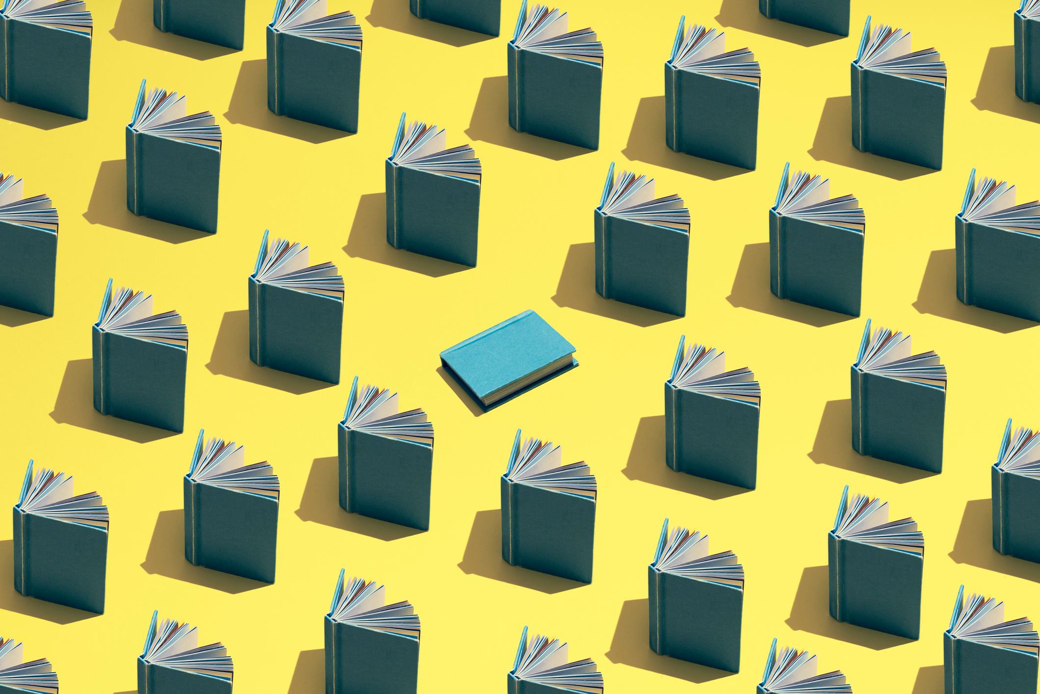 Immagine in evidenza del blog. Un'illustrazione di libri aperti disposti in file su uno sfondo giallo e un libro blu al centro.